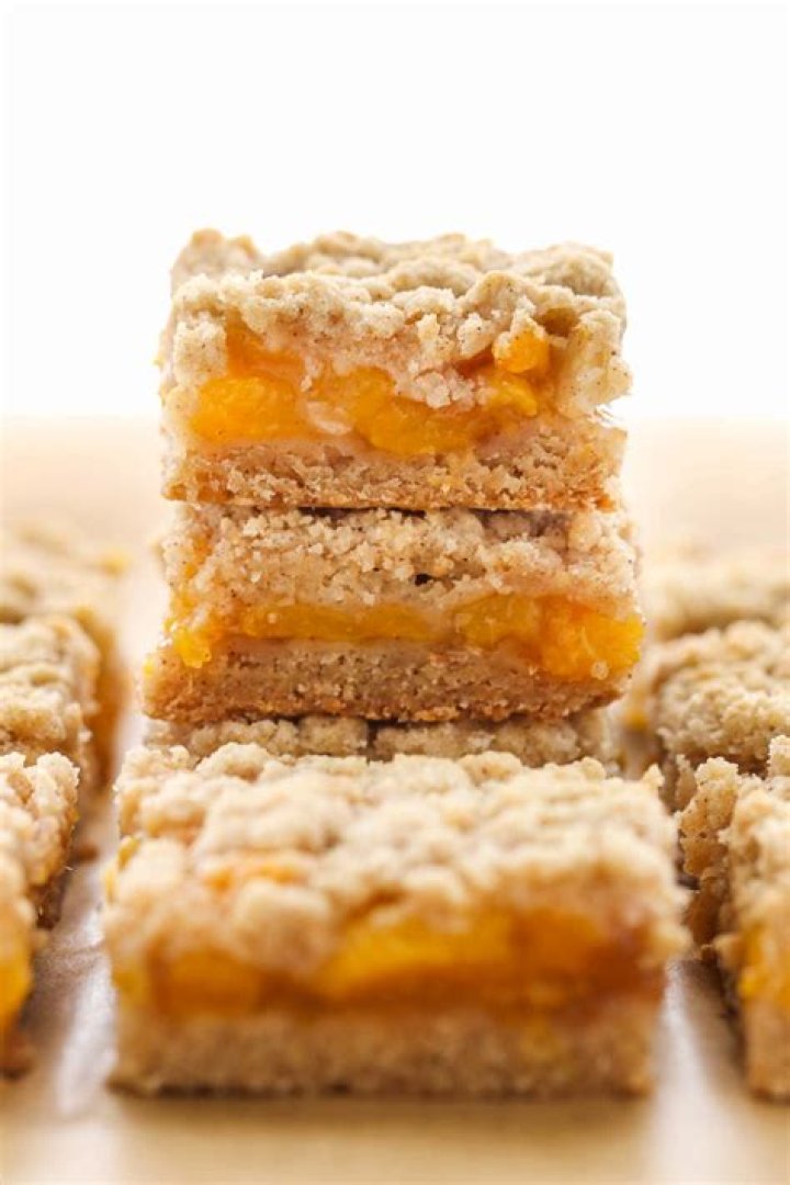 Stack of Peach Crumb Bars on a white plate.